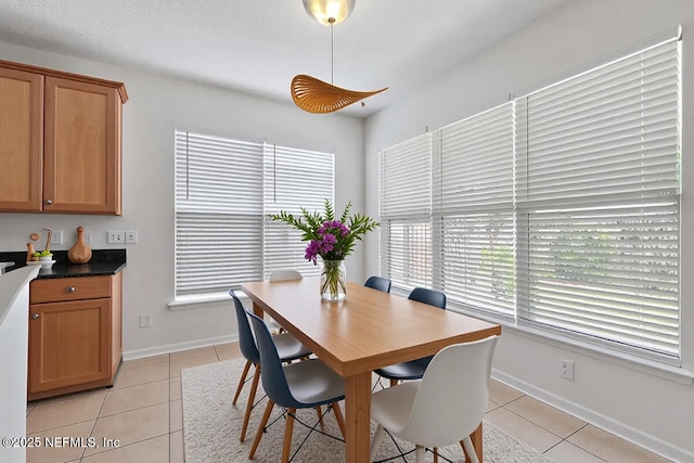dining area featuring light tile patterned flooring and baseboards