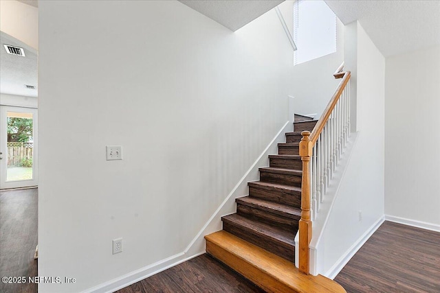 staircase with wood finished floors and baseboards