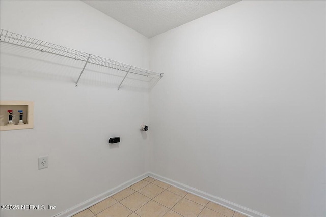 laundry room with electric dryer hookup, baseboards, hookup for a washing machine, and light tile patterned floors