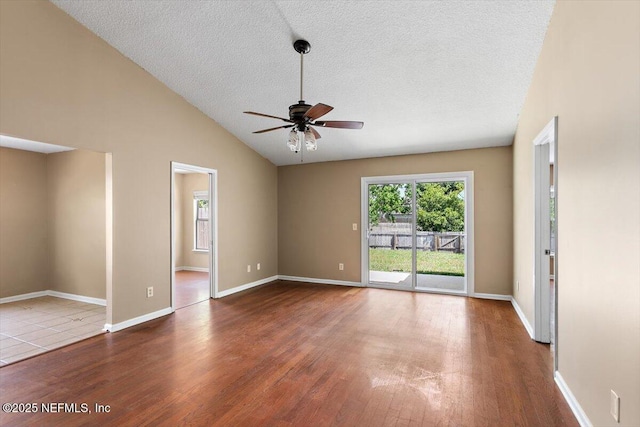 unfurnished room with a ceiling fan, wood finished floors, a textured ceiling, lofted ceiling, and baseboards