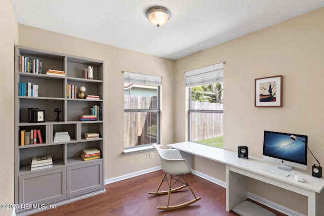office area with dark wood-style floors and baseboards