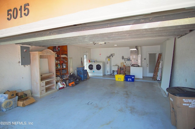 garage featuring washer and dryer, water heater, electric panel, and heating unit