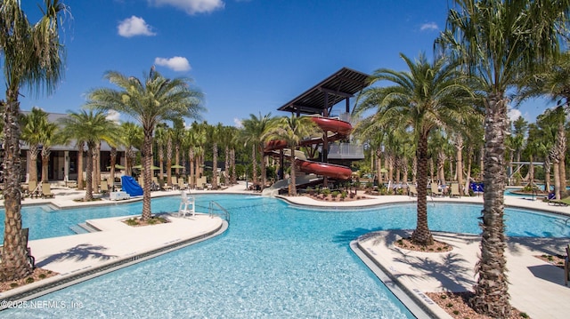 community pool featuring a water slide and a patio area