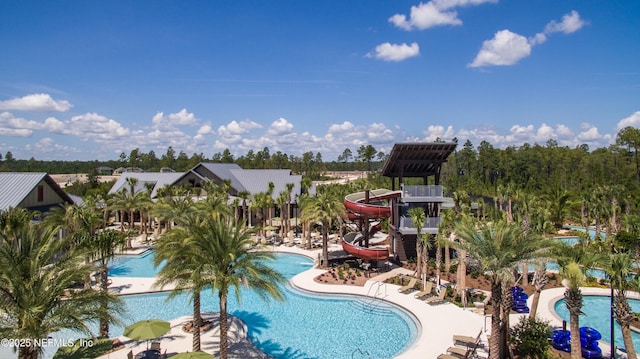 community pool featuring a water slide and a patio