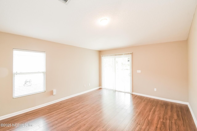 unfurnished room featuring baseboards and wood finished floors