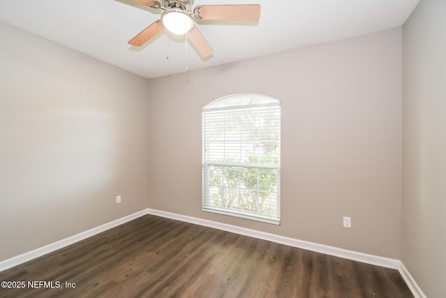 empty room featuring dark wood finished floors, baseboards, and ceiling fan