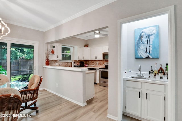 1303 Wood Hill Pl Unit 1303, Jacksonville, FL 32256 - kitchen featuring appliances with stainless steel finishes, a sink, white cabinetry, ornamental molding, and plenty of natural light