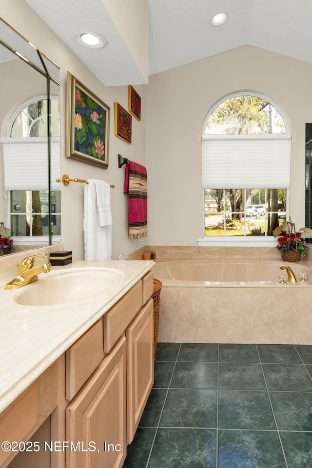 445 W Mill Chase Ct, Ponte Vedra Beach, FL 32082 - bathroom featuring vanity, healthy amount of natural light, a garden tub, vaulted ceiling, and tile patterned flooring