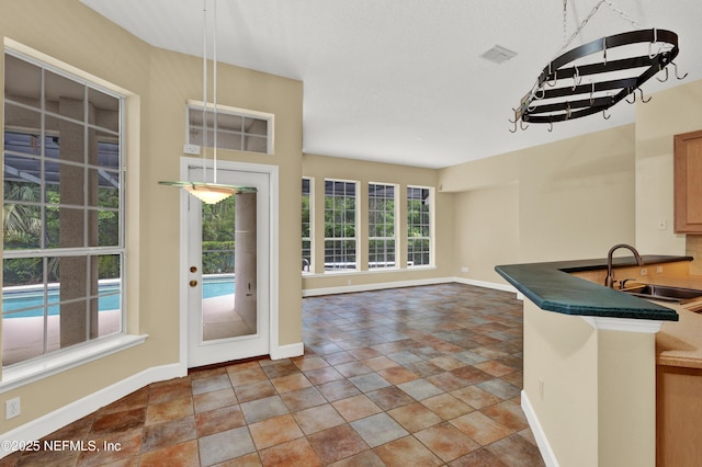 445 W Mill Chase Ct, Ponte Vedra Beach, FL 32082 - kitchen with a sink, baseboards, dark countertops, and stone finish flooring
