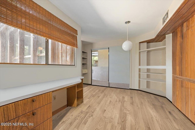7868 Woodsdale Ln, Jacksonville, FL 32256 - unfurnished office with built in desk, built in shelves, and light wood-style flooring