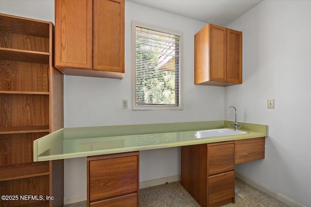 7868 Woodsdale Ln, Jacksonville, FL 32256 - kitchen with a sink, brown cabinetry, open shelves, and baseboards