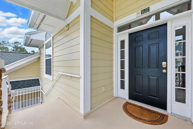 property entrance featuring a shingled roof