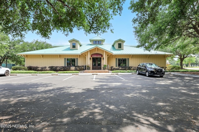 view of front of home with uncovered parking and metal roof
