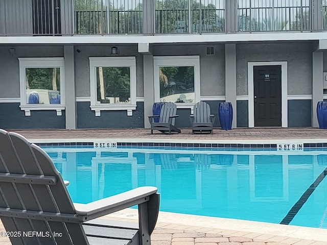 outdoor pool with a patio area