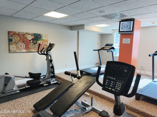 workout area with carpet flooring, baseboards, and a drop ceiling