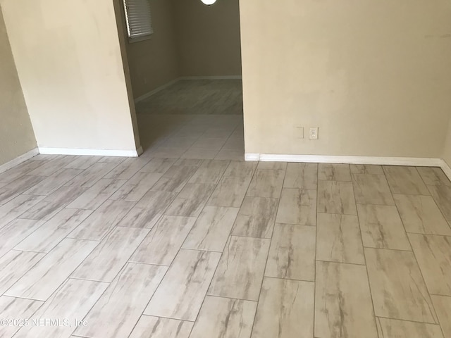 empty room featuring baseboards and wood finish floors