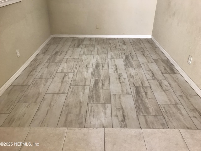 spare room featuring wood finished floors and baseboards