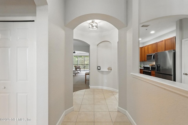 200 Paseo Terraza Unit 203, Saint Augustine, FL 32095 - hallway with arched walkways, light tile patterned floors, recessed lighting, and baseboards