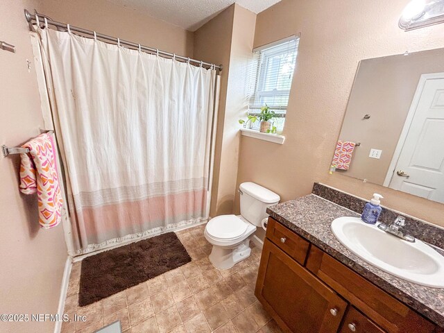 bathroom featuring toilet, vanity, and curtained shower