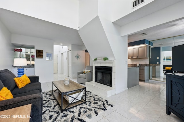 9360 Craven Rd Unit 1406, Jacksonville, FL 32257 - living room featuring light tile patterned floors, a fireplace, baseboards, and a towering ceiling