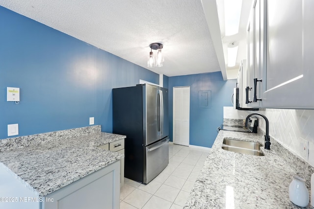 9360 Craven Rd Unit 1406, Jacksonville, FL 32257 - kitchen with freestanding refrigerator, a sink, backsplash, light tile patterned floors, and light stone counters