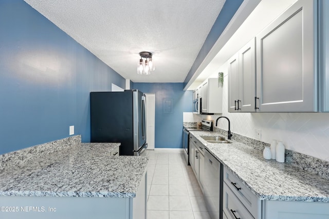9360 Craven Rd Unit 1406, Jacksonville, FL 32257 - kitchen featuring stainless steel appliances, a sink, a textured ceiling, baseboards, and light tile patterned floors