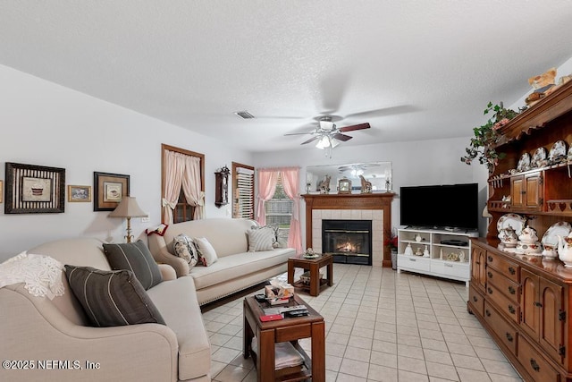 3041 Marrano Dr, Orange Park, FL 32073 - living room with light tile patterned floors, a ceiling fan, a fireplace, and a textured ceiling