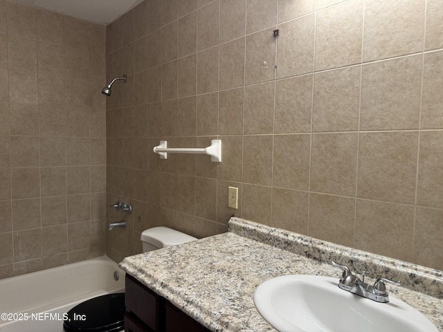 bathroom with vanity,  shower combination, toilet, and tile walls