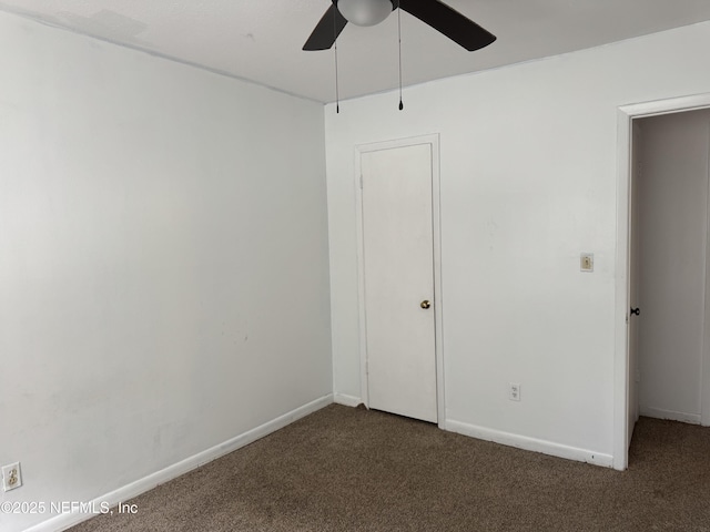 unfurnished bedroom with dark carpet, baseboards, and ceiling fan