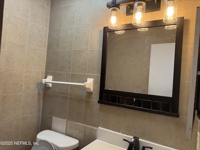 bathroom featuring toilet and tile walls