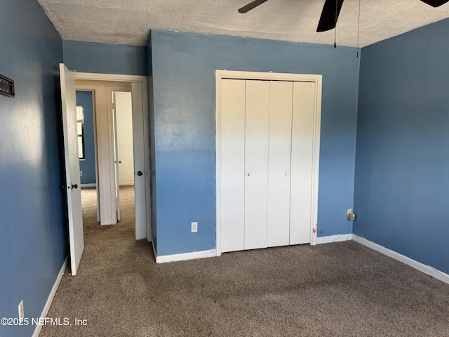 unfurnished bedroom with carpet, baseboards, a closet, a textured ceiling, and ceiling fan