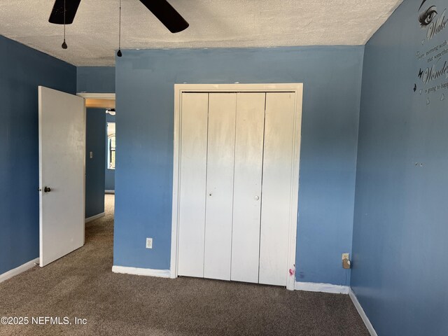 unfurnished bedroom featuring carpet flooring, a textured ceiling, baseboards, and a closet