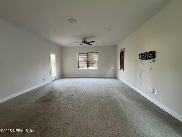 empty room with carpet flooring, baseboards, and a ceiling fan