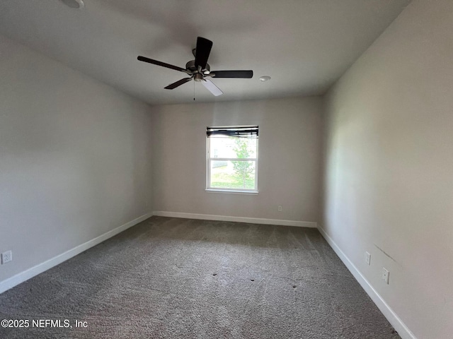 carpeted empty room featuring baseboards and ceiling fan