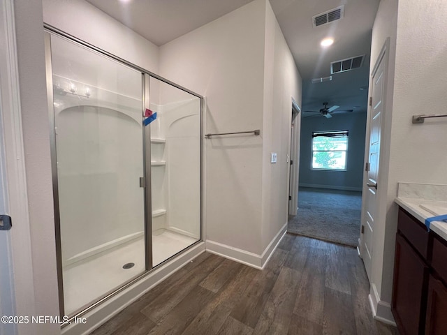 full bath with a stall shower, wood finished floors, and ceiling fan