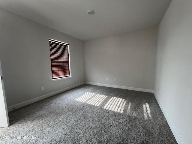 spare room featuring carpet and baseboards