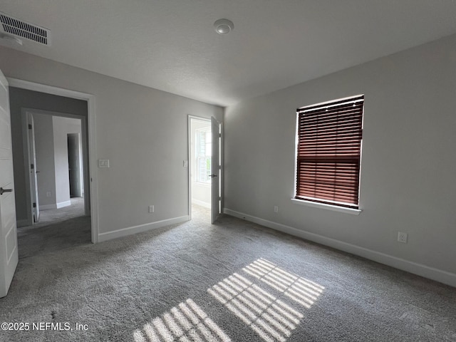 carpeted empty room featuring baseboards