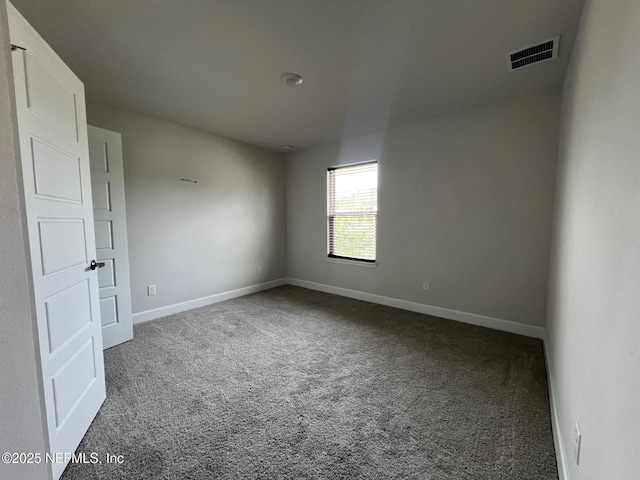 carpeted spare room featuring baseboards