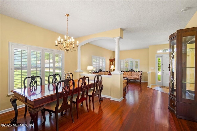 11092 Turnbridge Dr Unit 74, Jacksonville, FL 32256 - dining area featuring ornate columns, dark wood-style floors, a chandelier, baseboards, and a textured ceiling