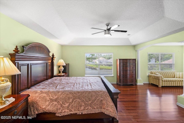 11092 Turnbridge Dr Unit 74, Jacksonville, FL 32256 - bedroom with ornate columns, wood finished floors, a textured ceiling, a raised ceiling, and arched walkways