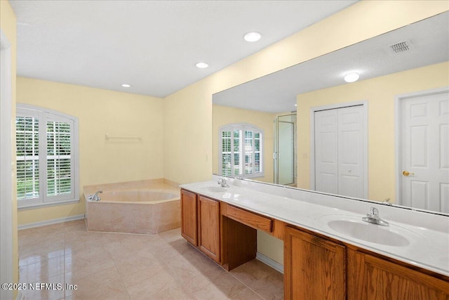 11092 Turnbridge Dr Unit 74, Jacksonville, FL 32256 - bathroom featuring a garden tub, double vanity, a closet, and an enclosed shower