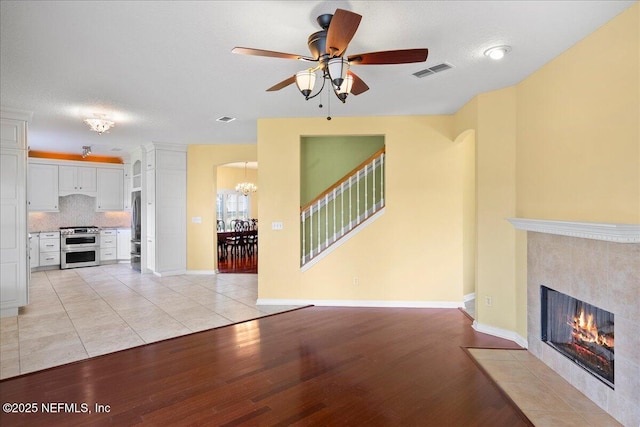 11092 Turnbridge Dr Unit 74, Jacksonville, FL 32256 - unfurnished living room with light wood-type flooring, a chandelier, ceiling fan, and a fireplace