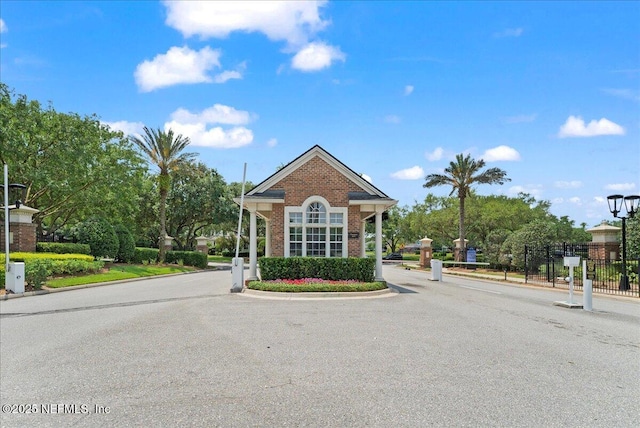 11092 Turnbridge Dr Unit 74, Jacksonville, FL 32256 - view of asphalt road with curbs, street lighting, and a gated entry