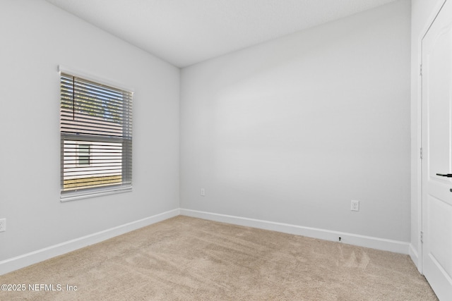 carpeted spare room with baseboards