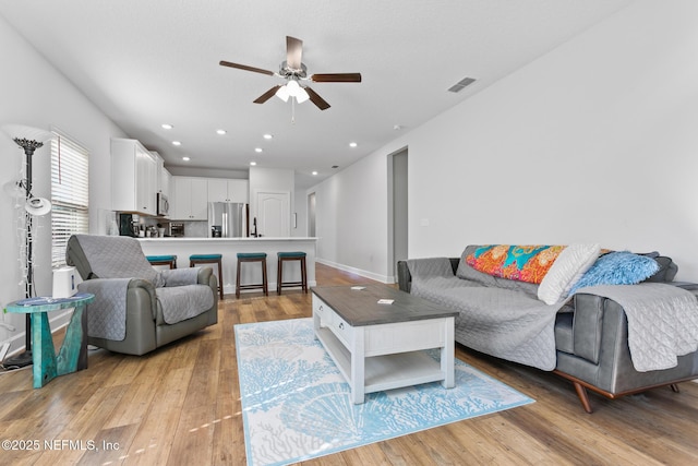living area featuring a ceiling fan, light wood-style flooring, and recessed lighting