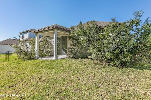 rear view of property featuring a ceiling fan and a patio area