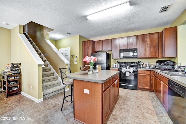8672 Ribbon Falls Ln, Jacksonville, FL 32244 - kitchen featuring black appliances, a sink, a kitchen island, a kitchen bar, and a textured ceiling