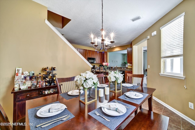 8672 Ribbon Falls Ln, Jacksonville, FL 32244 - dining area with a chandelier, tile patterned floors, and baseboards
