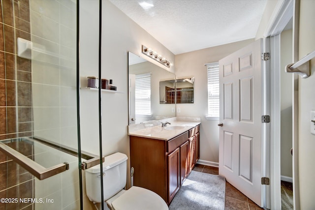 8672 Ribbon Falls Ln, Jacksonville, FL 32244 - bathroom featuring toilet, tile patterned flooring, vanity, a textured ceiling, and a tile shower
