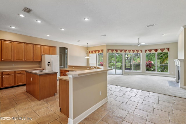 2260 Harbor Lake Dr, Fleming Island, FL 32003 - kitchen featuring a center island with sink, light carpet, arched walkways, white fridge with ice dispenser, and a ceiling fan
